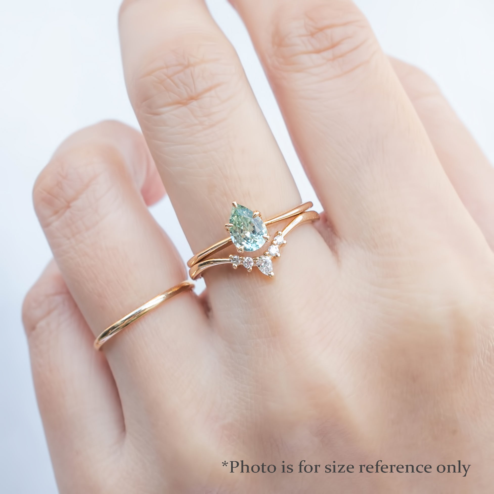 Hand wearing Sara Ring with unheated 0.50ct Madagascar sapphire in 14k recycled yellow gold flower setting