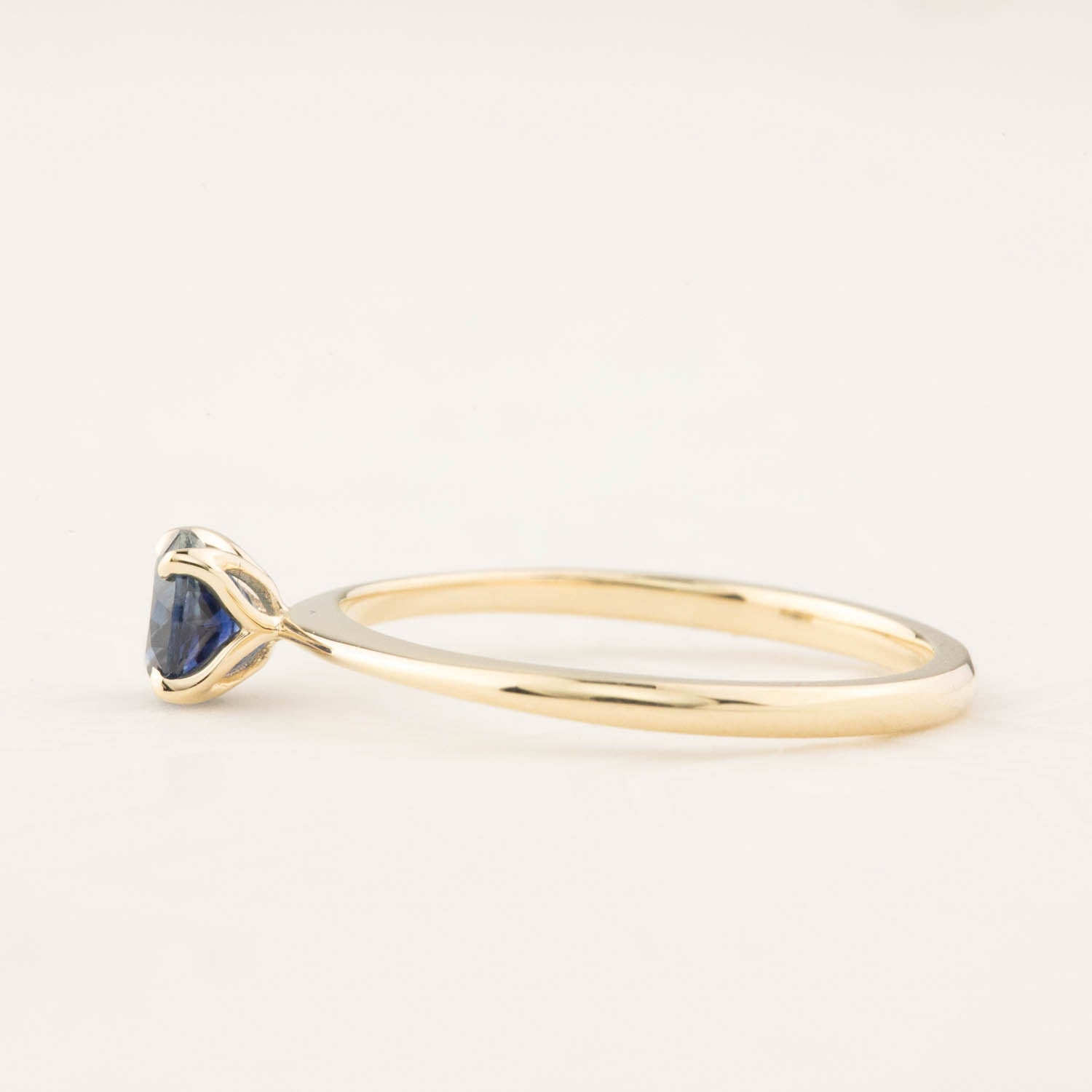 Side view of Sara Ring featuring 0.66ct teal Montana sapphire set in recycled 14k yellow gold band
