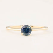14k yellow gold ring with 0.66ct teal Montana sapphire center stone in delicate tapered band setting