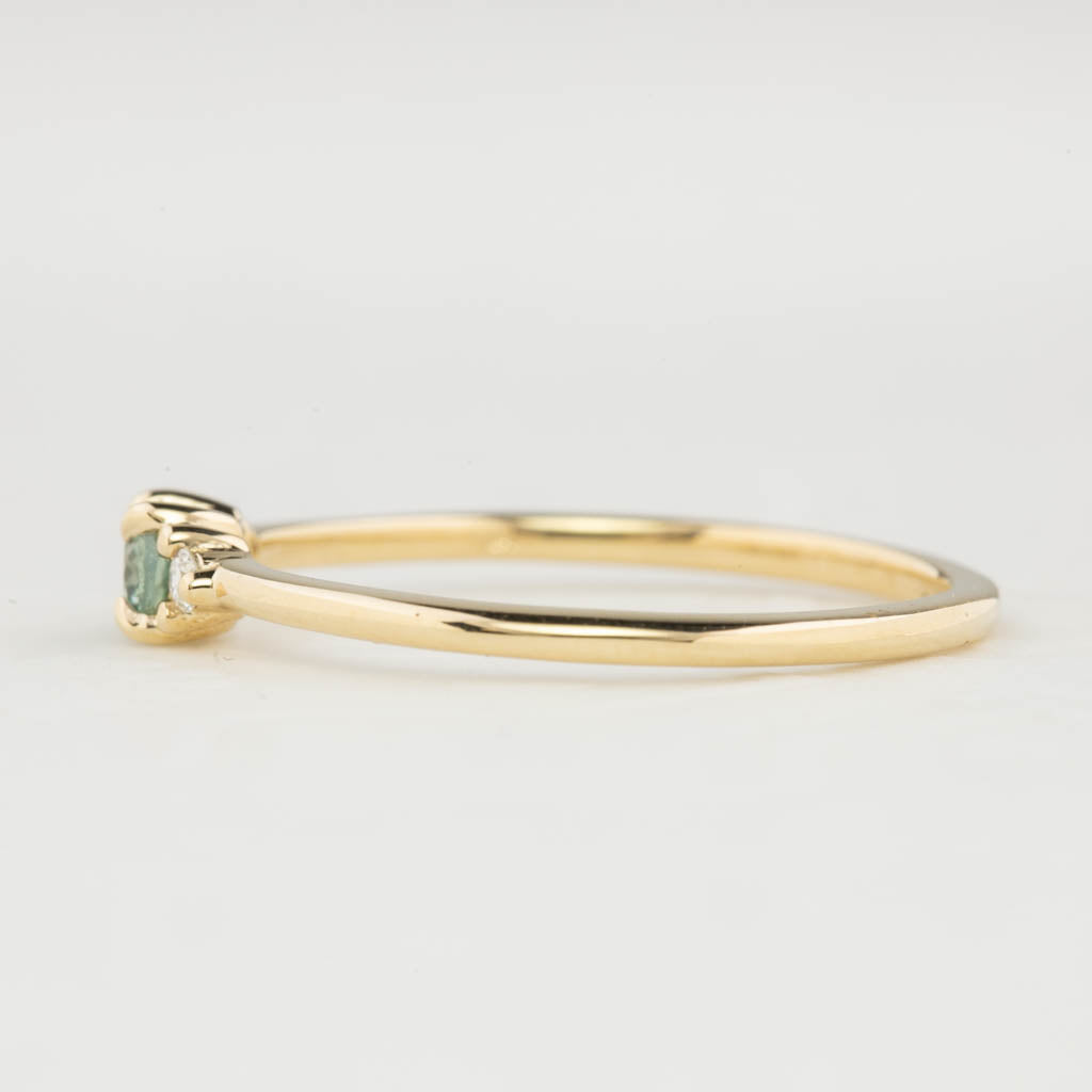 Side view of Emilie Ring featuring a 0.20ct East-West set oval Montana sapphire in 14k yellow gold.