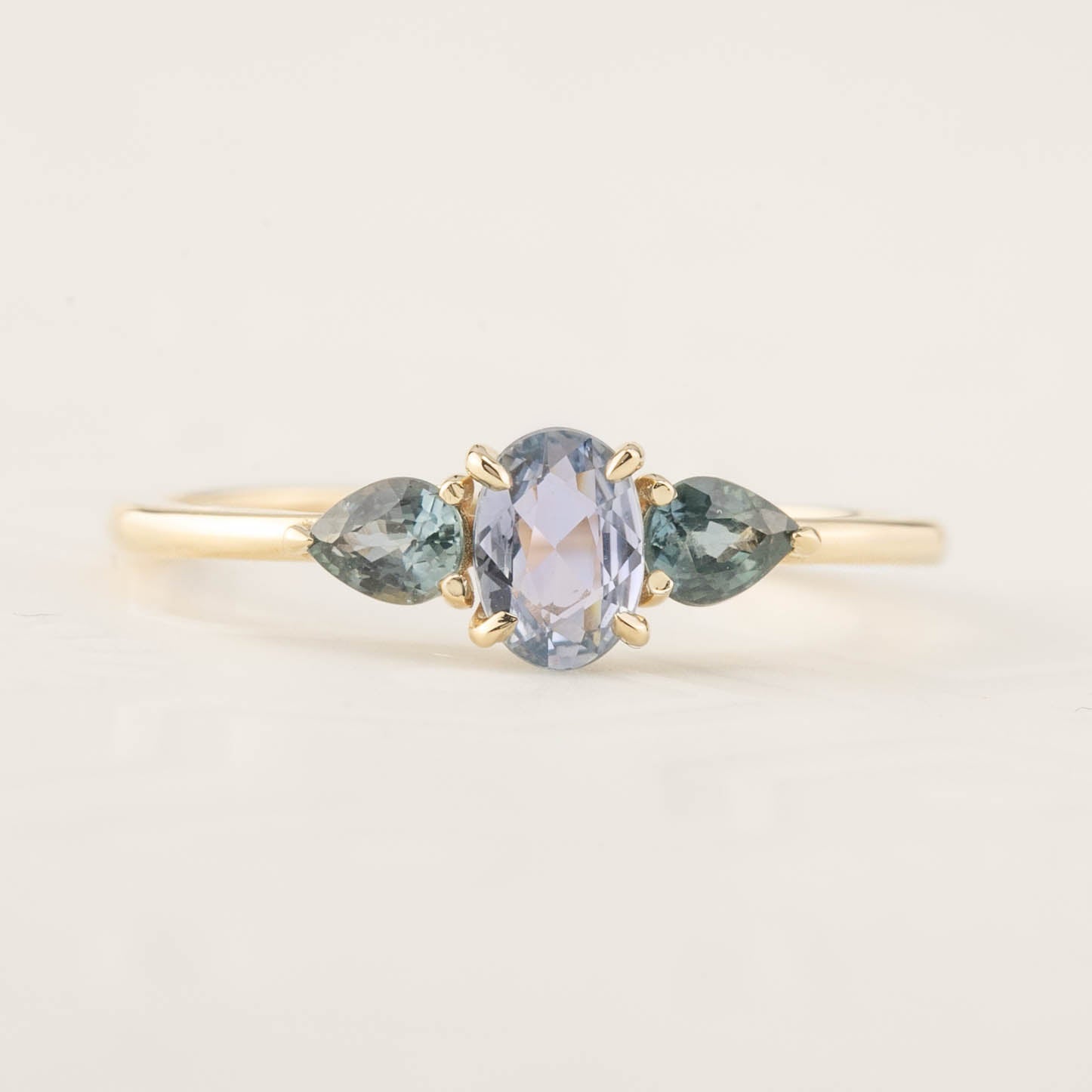 Blue sapphire three stone ring with teardrop peacock sapphires set in recycled 14k gold low profile band