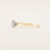 Side view of one-of-a-kind blue sapphire three stone ring with recycled 14k gold prong setting