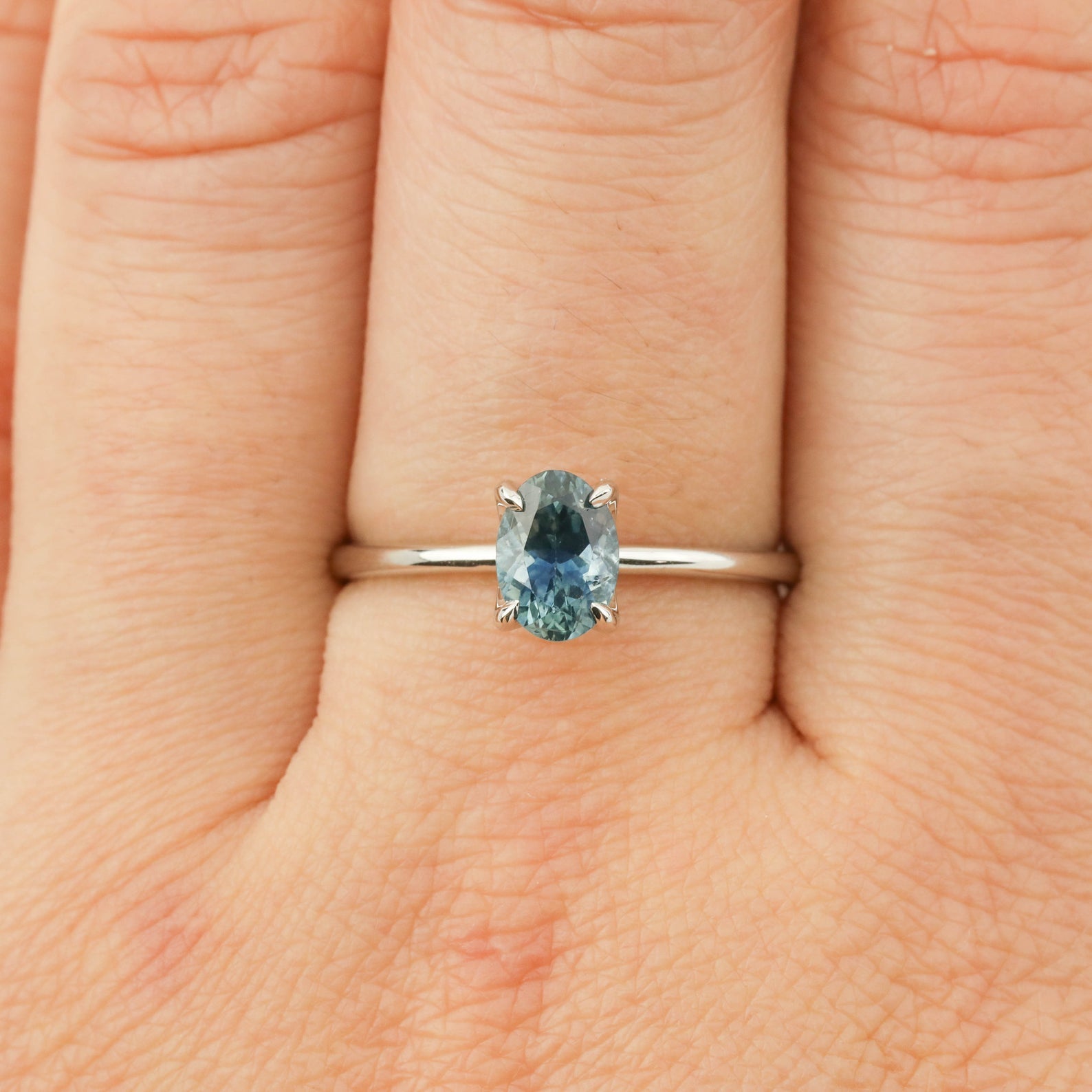Close-up of Sara Ring featuring 1.00ct parti blue green Montana sapphire set in 14k white gold on finger size 7