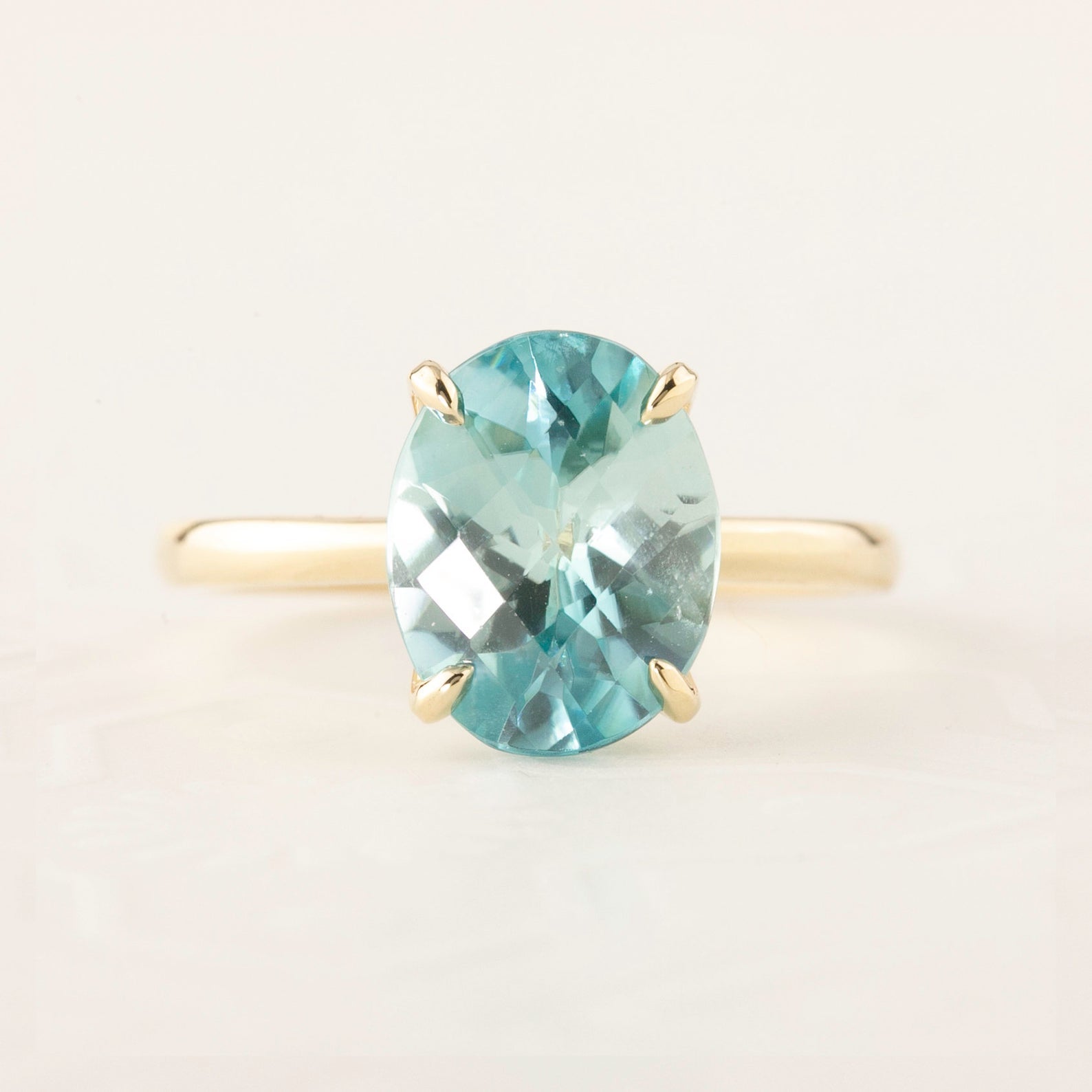 Oval blue zircon ring with checkerboard cut set in 14k yellow gold, size 7, elegant and resizable band design