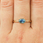 Sara Ring featuring a 1ct parti blue green Montana Sapphire set in recycled 14k yellow gold band, size 7 shown on finger