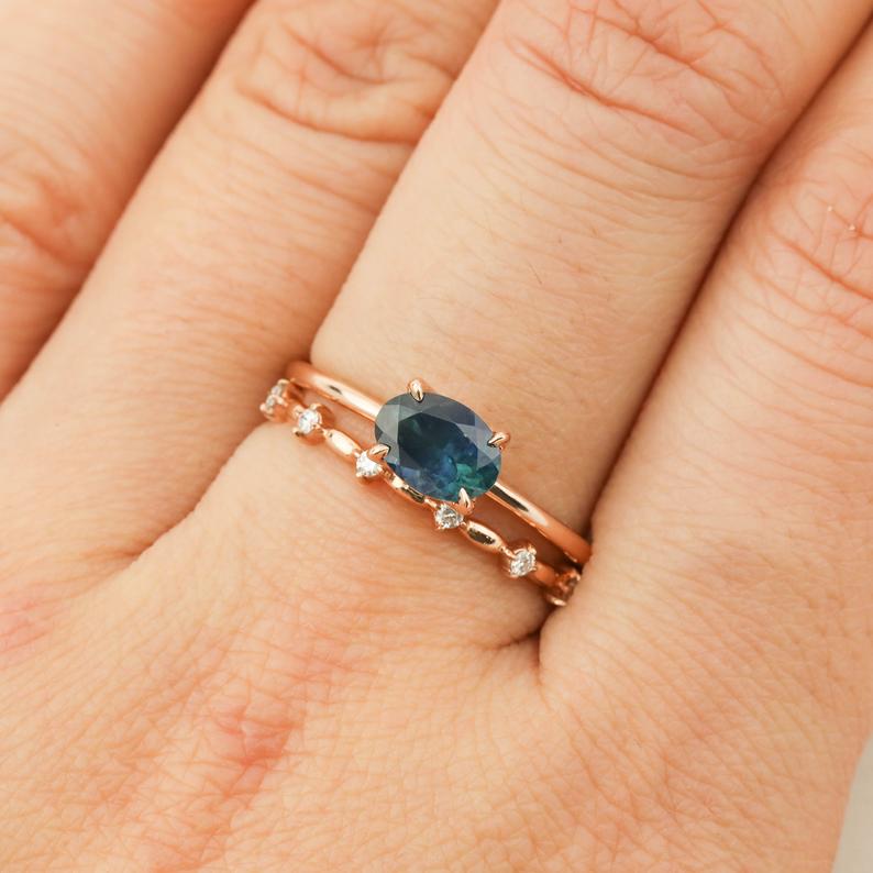 Hand wearing Sara Ring with 1.00ct green Montana sapphire set in 14k rose gold band with small diamonds