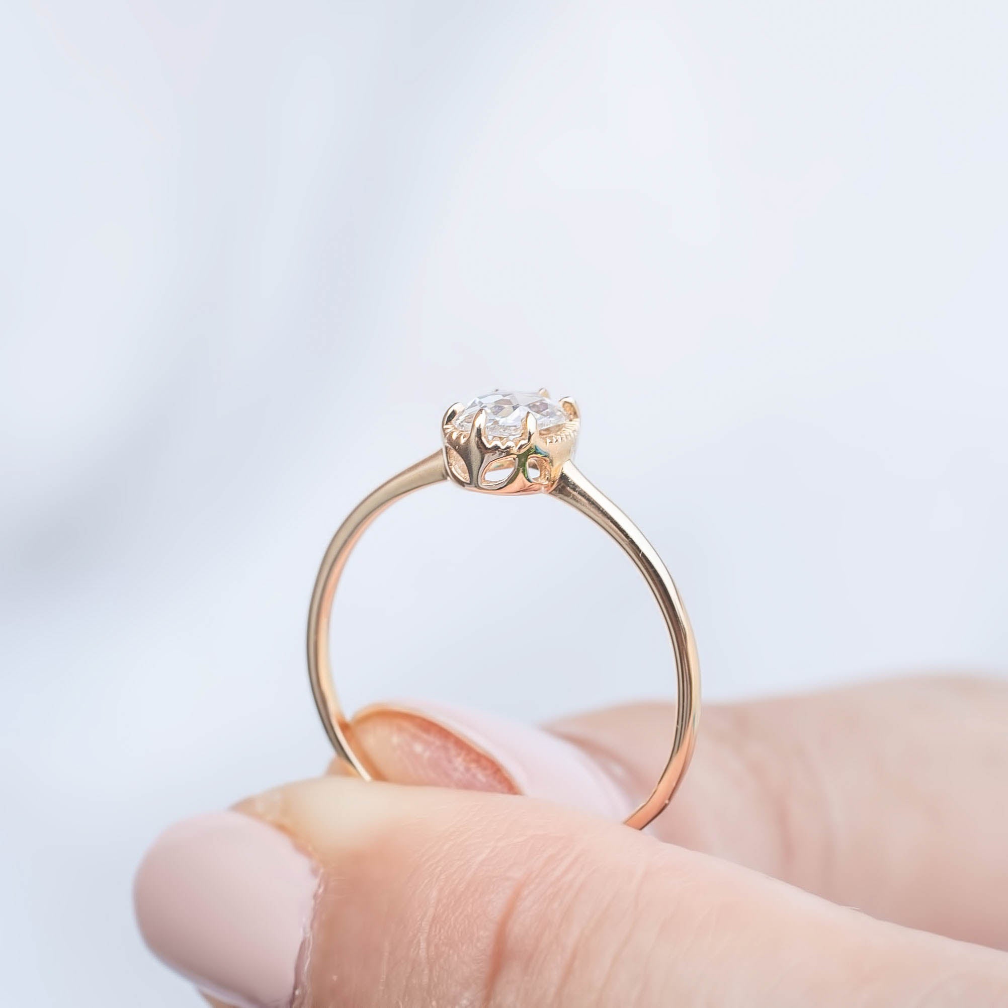Hand holding Ava Ring with oval rose cut diamond in recycled metal low profile bezel setting