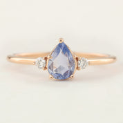 Stunning Emilie Ring featuring a teardrop-shaped unheated blue sapphire and sparkling accent diamonds in 14k rose gold.