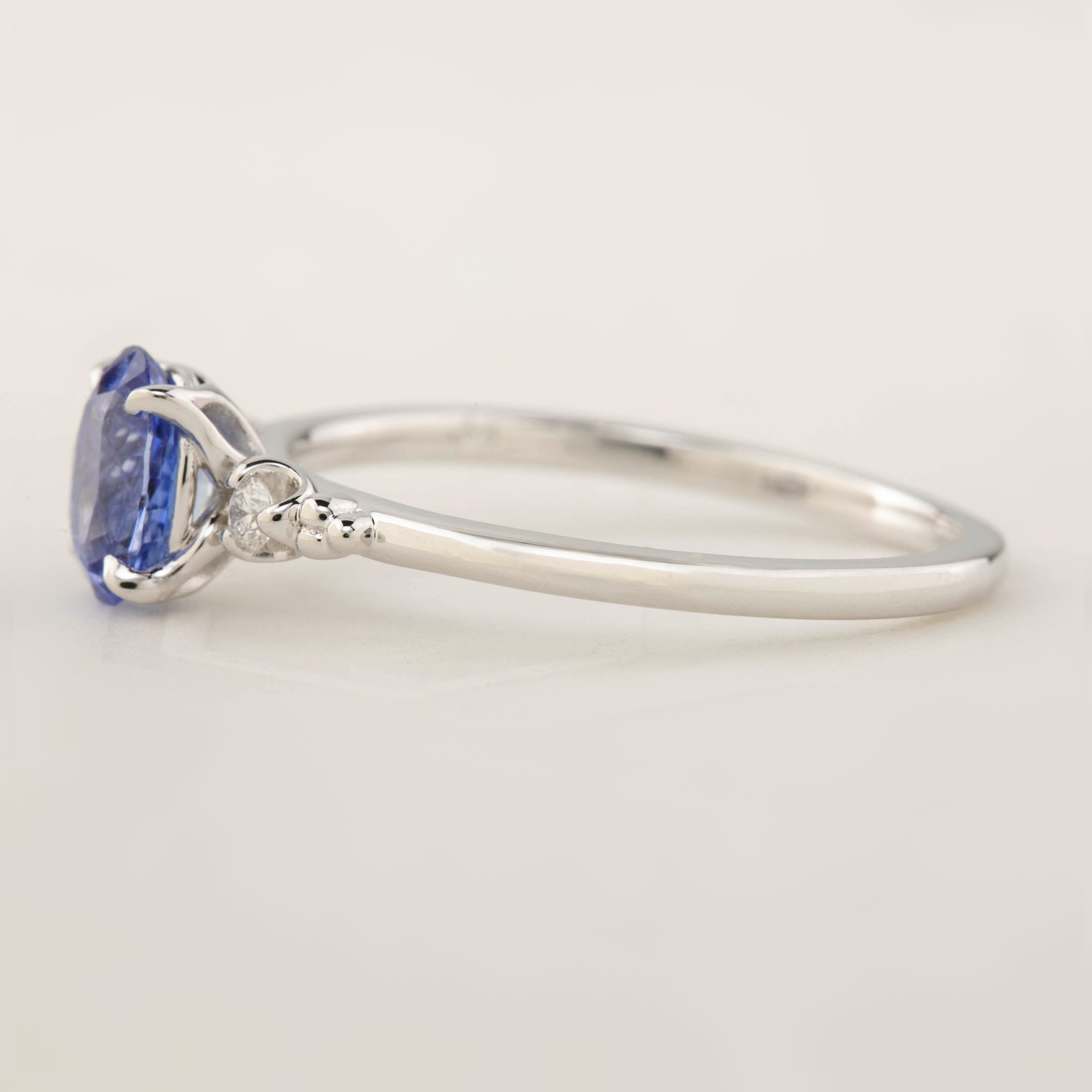 Side view of Estel Ring with 1.01ct Blue Ceylon Sapphire and white gold band in a four-prong flower setting