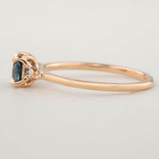 Delicate 14k rose gold ring with 0.76ct cushion Montana sapphire and 0.04ct natural accent diamonds in flower setting