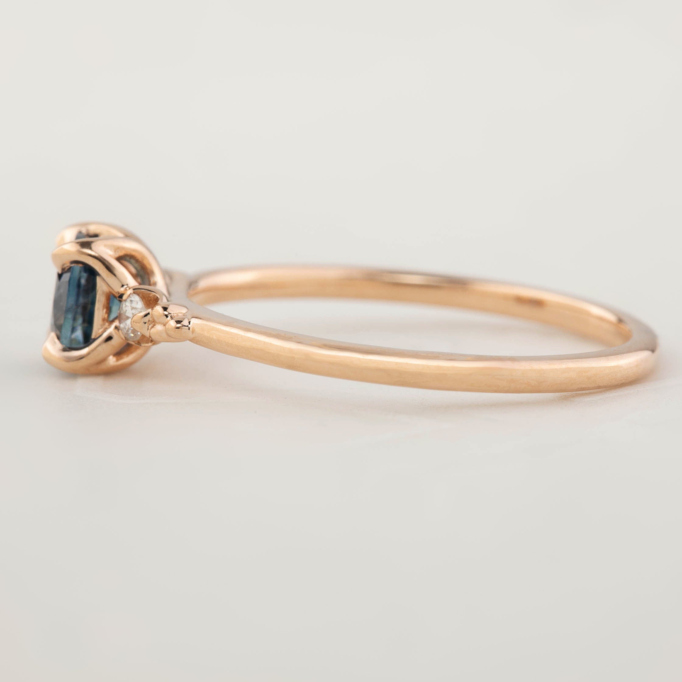 Delicate 14k rose gold ring with 0.76ct cushion Montana sapphire and 0.04ct natural accent diamonds in flower setting