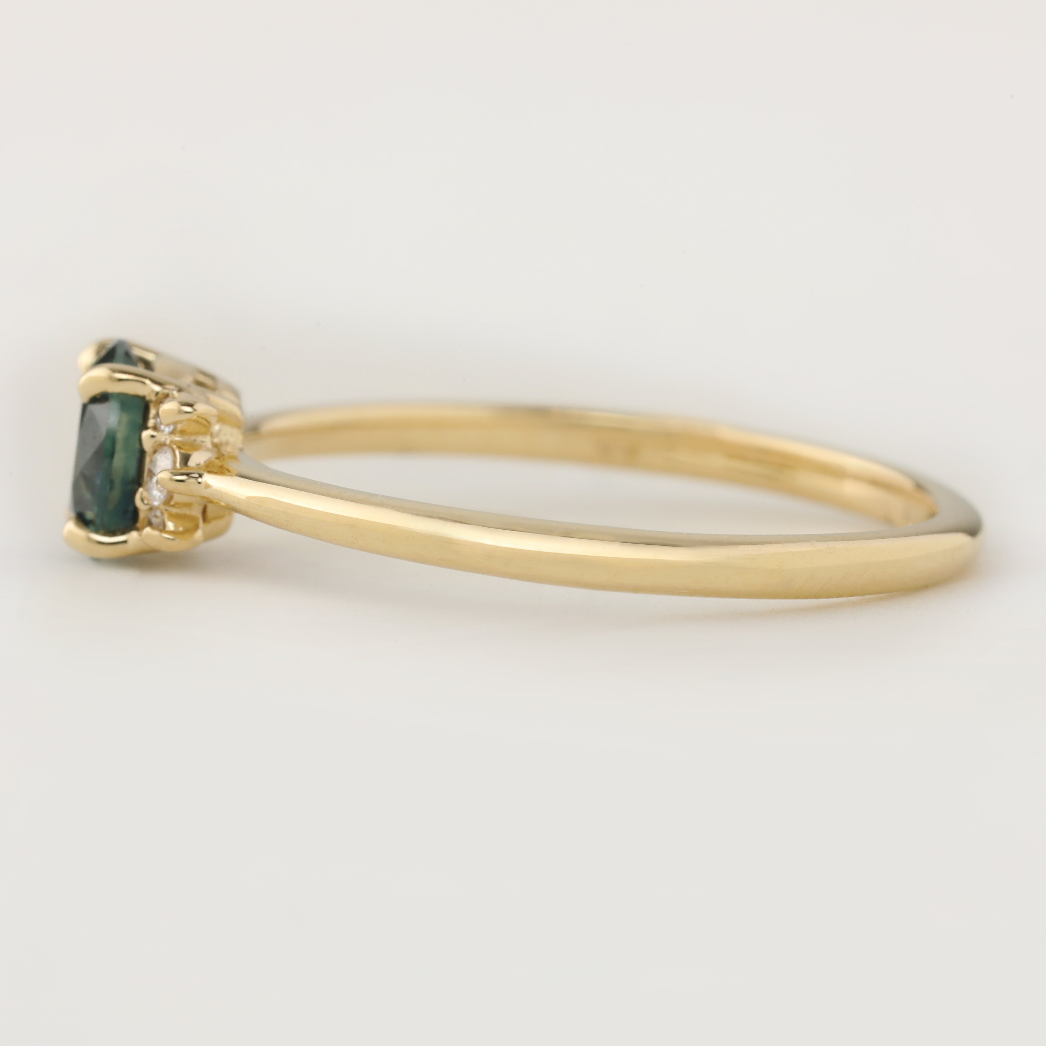 Lena Ring featuring a 0.65ct teal blue Montana Sapphire with white diamonds in recycled 14k gold band.
