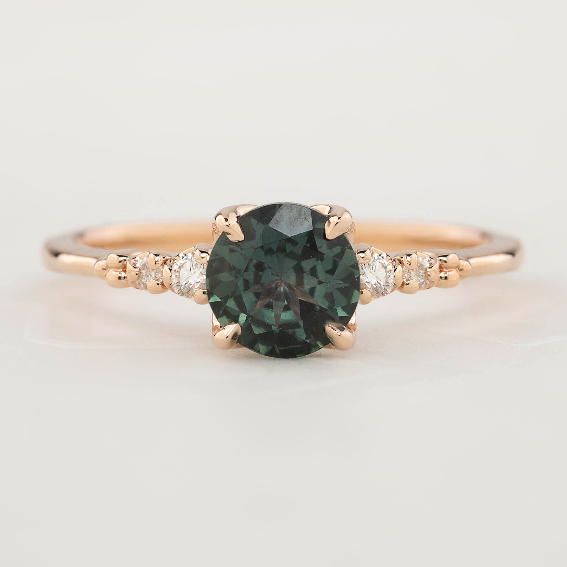 Estel Luxe Ring featuring a 0.97ct peacock green Montana sapphire and white diamond accents in rose gold band.