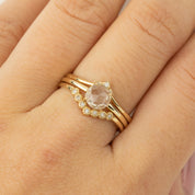 Close-up of a hand wearing a 0.88ct white sapphire Lisa Ring set in recycled 14k gold with small accent diamonds.