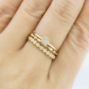 Close-up of a hand wearing a gold Aria Eternity Ring with natural white diamonds in a full-eternity design