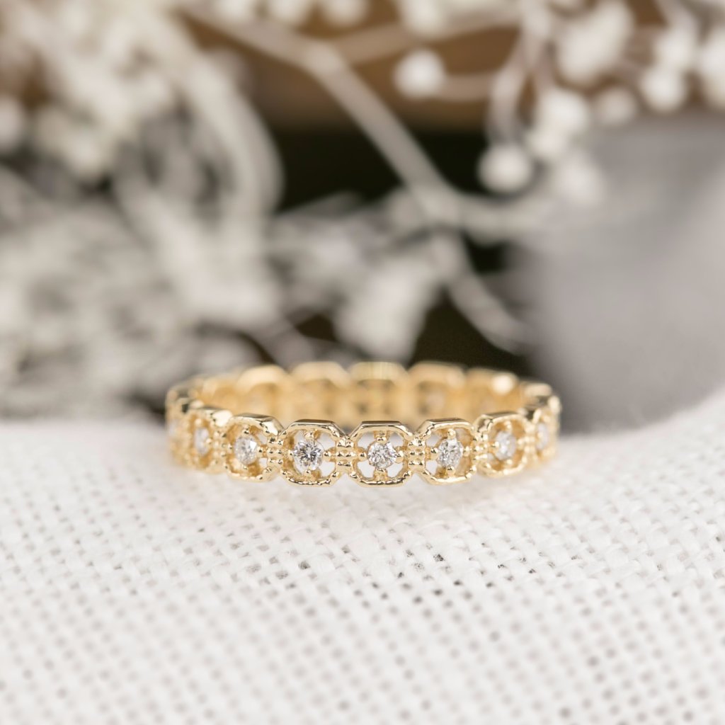 Milgrain square eternity ring with natural white diamonds set in solid gold on textured fabric background