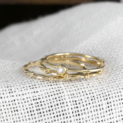 Close-up of Julia Ring stack featuring a 1.7mm ethically sourced solid gold band with a single small diamond bead detail