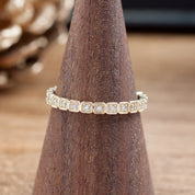 Hazel Eternity Ring with natural white diamonds set in solid gold on a wooden ring display cone