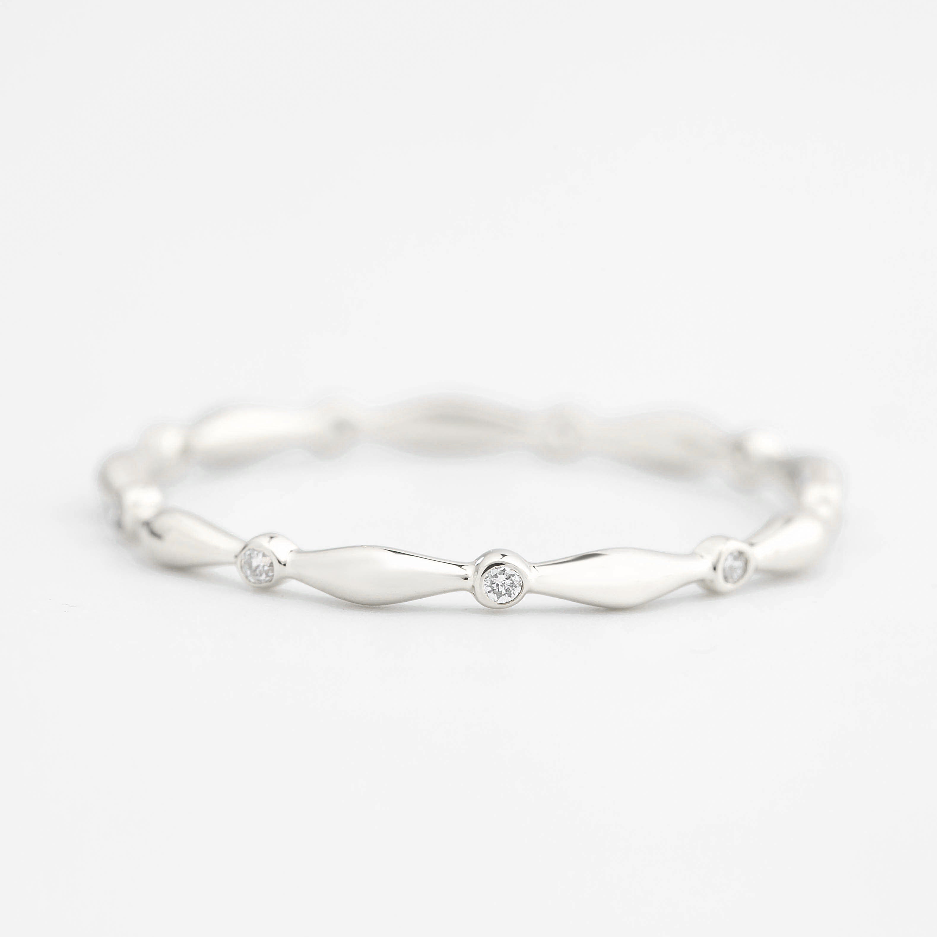 Close-up of Aria Eternity Ring featuring natural white diamonds set in a delicate solid gold band with a polished finish.