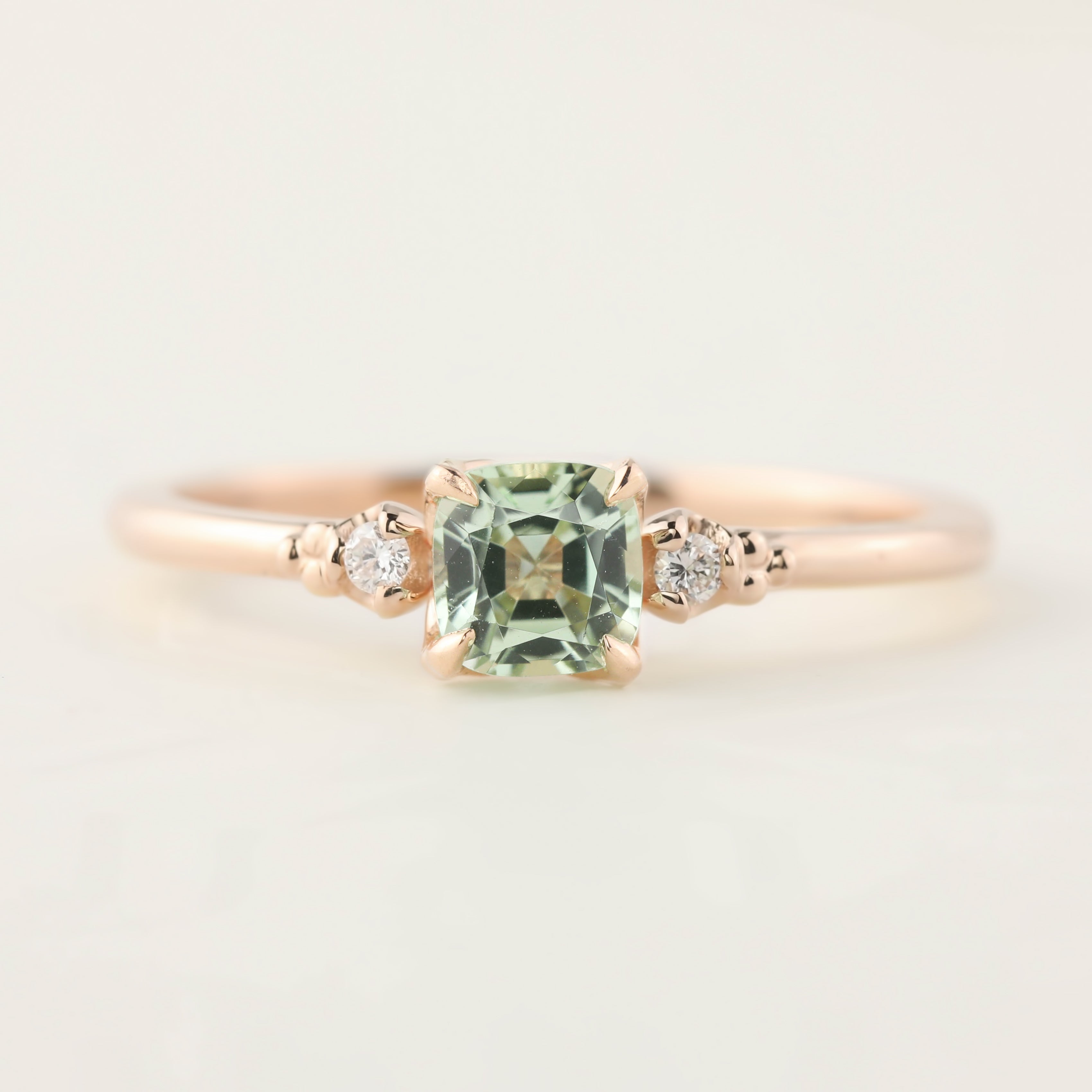 Rose gold ring with 0.5ct radiant cut mint tourmaline and two small diamonds on a delicate band