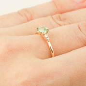 Close-up of Estel ring with 0.5ct radiant cut mint tourmaline in 14k yellow gold on finger