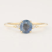 14k gold ring with 1.25ct blue sapphire and two small white diamond accents in flower setting