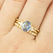 Close-up of a 14k gold Estel ring featuring a 1.53ct blue sapphire with diamond accents on a finger.