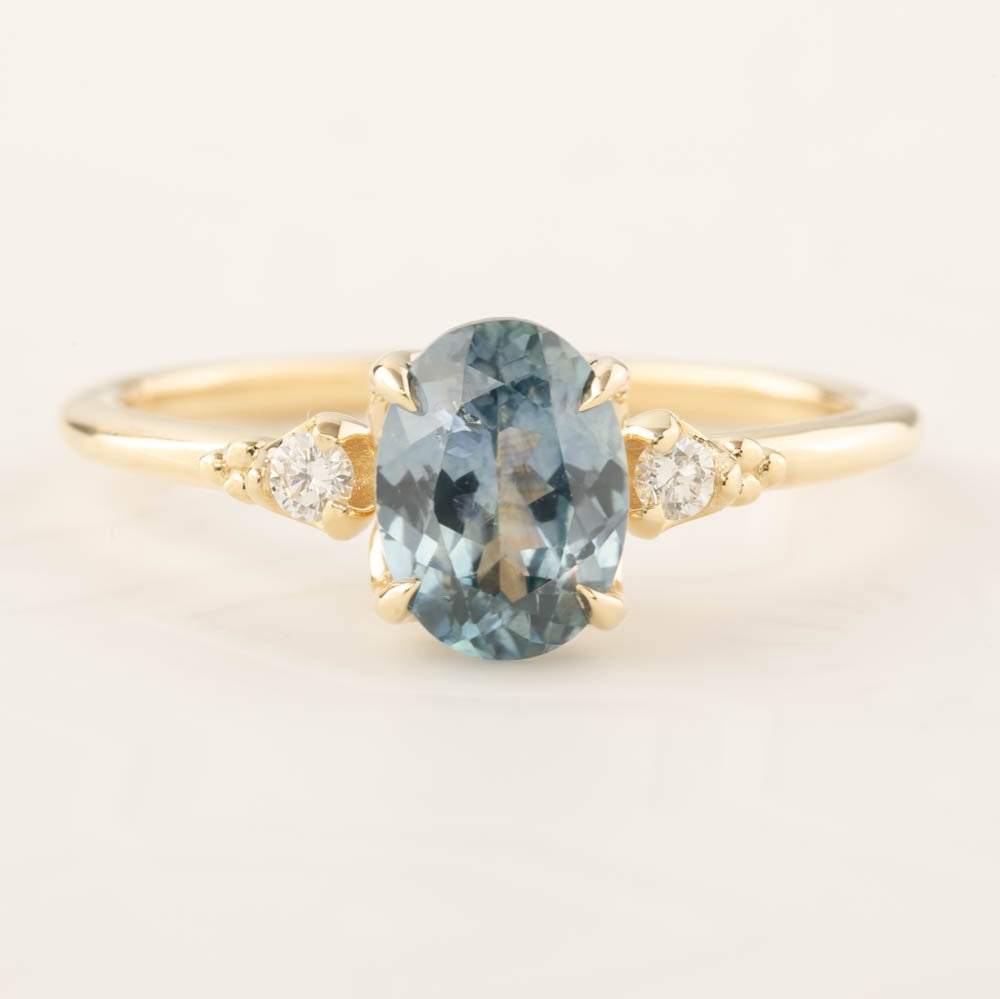 Estel Ring featuring a 1.4ct light blue-green Montana Sapphire with white diamond accents in 14k recycled gold