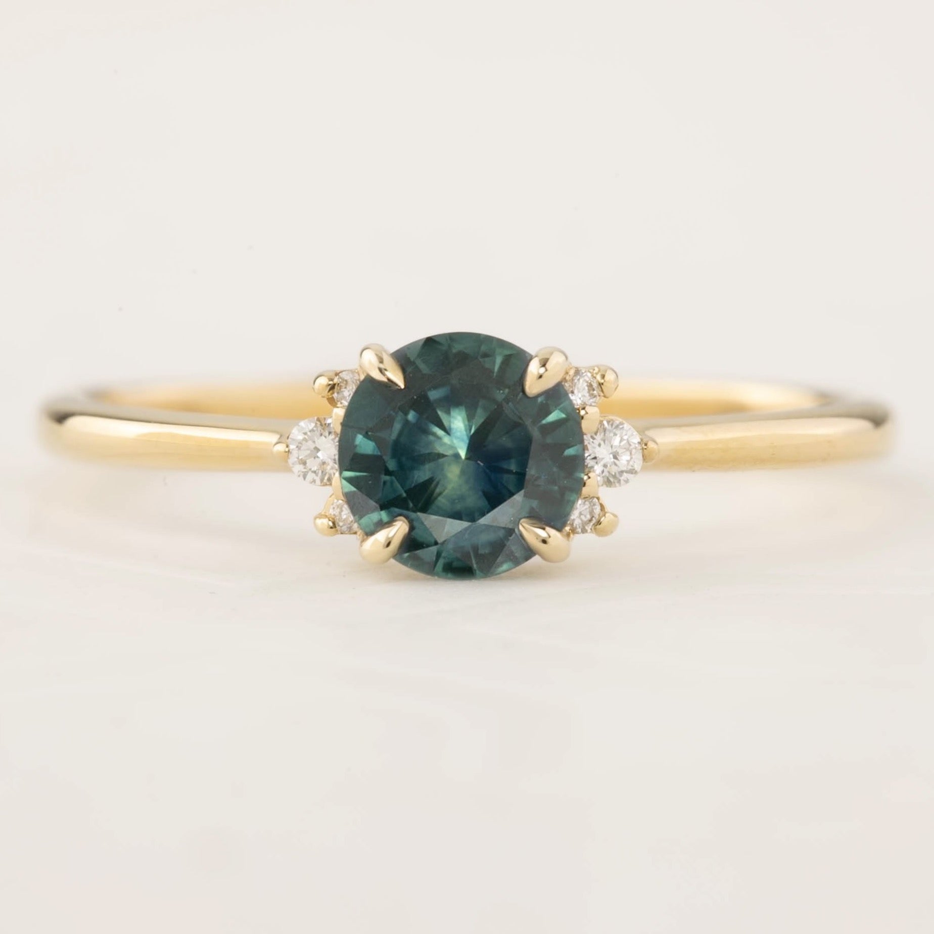 Lena Ring with 0.65ct teal blue Montana Sapphire, white accent diamonds, 14k yellow gold, handmade and ethically sourced