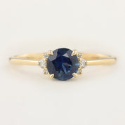 Stunning Lena Ring featuring a 1.18ct blue Montana sapphire, set in 14k yellow gold with sparkling diamond accents.