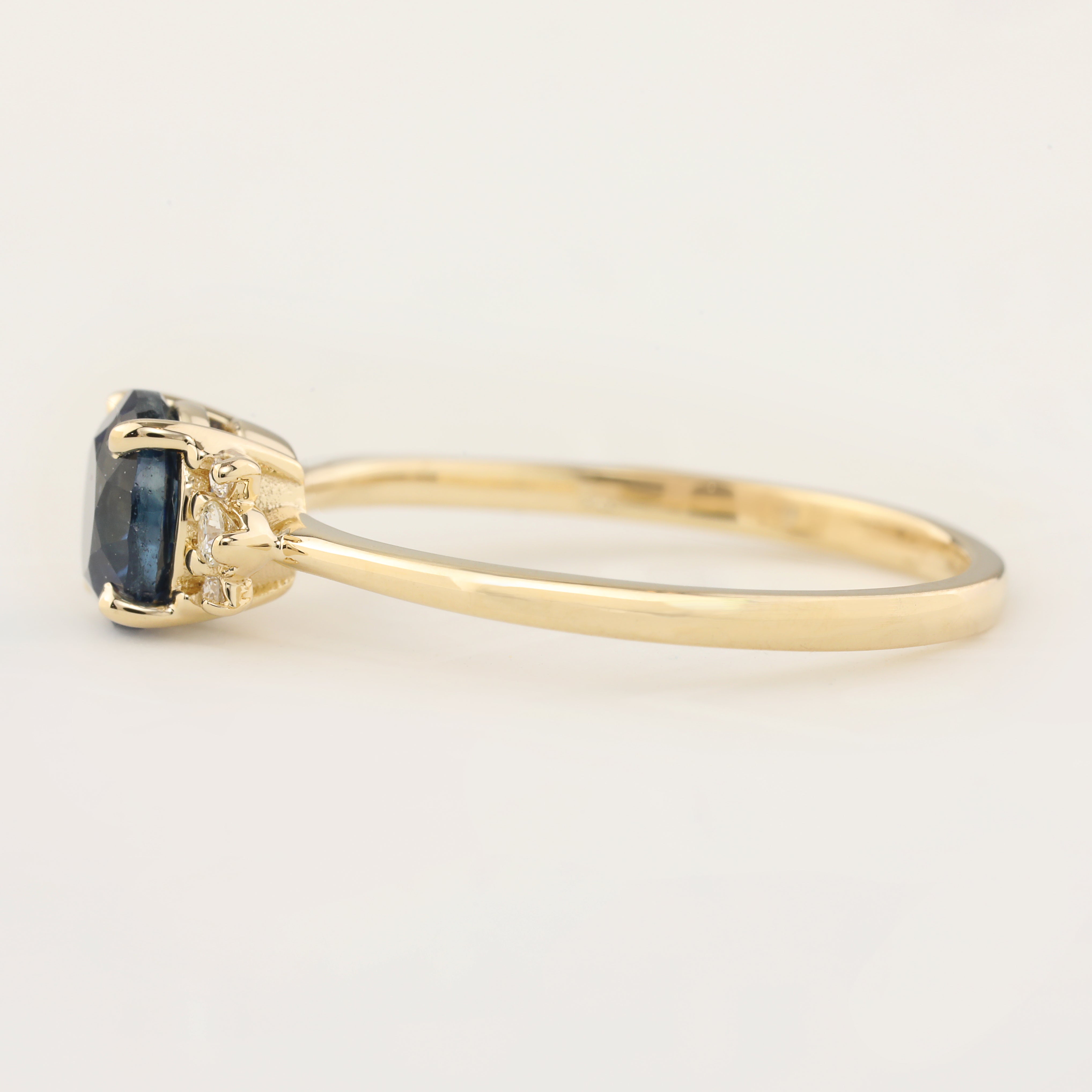 Stunning Lena Ring featuring a 1.18ct blue Montana sapphire with sparkling white accent diamonds in 14k yellow gold.