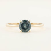 Close-up of Nina Ring featuring 0.94ct teal blue Montana sapphire set in 14k yellow gold tapered band
