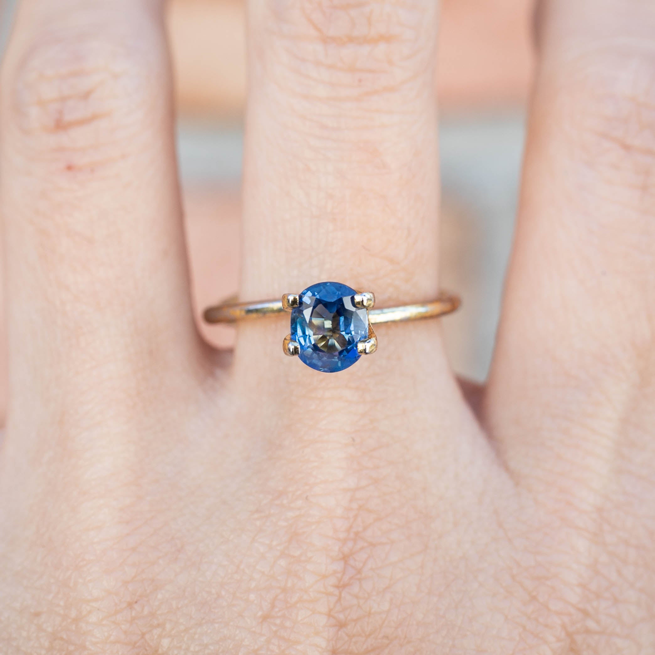 1.32ct Oval Cut Unheated Blue Sapphire ring on finger, showcasing its authentic deep blue color and oval shape
