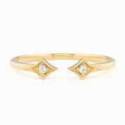 Delicate open gold ring with two star-shaped settings each holding a small brilliant cut white diamond