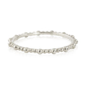 Close-up of a Gemma full eternity bead ring in solid gold with a delicate 1.5mm band, ethically sourced and unresizable.